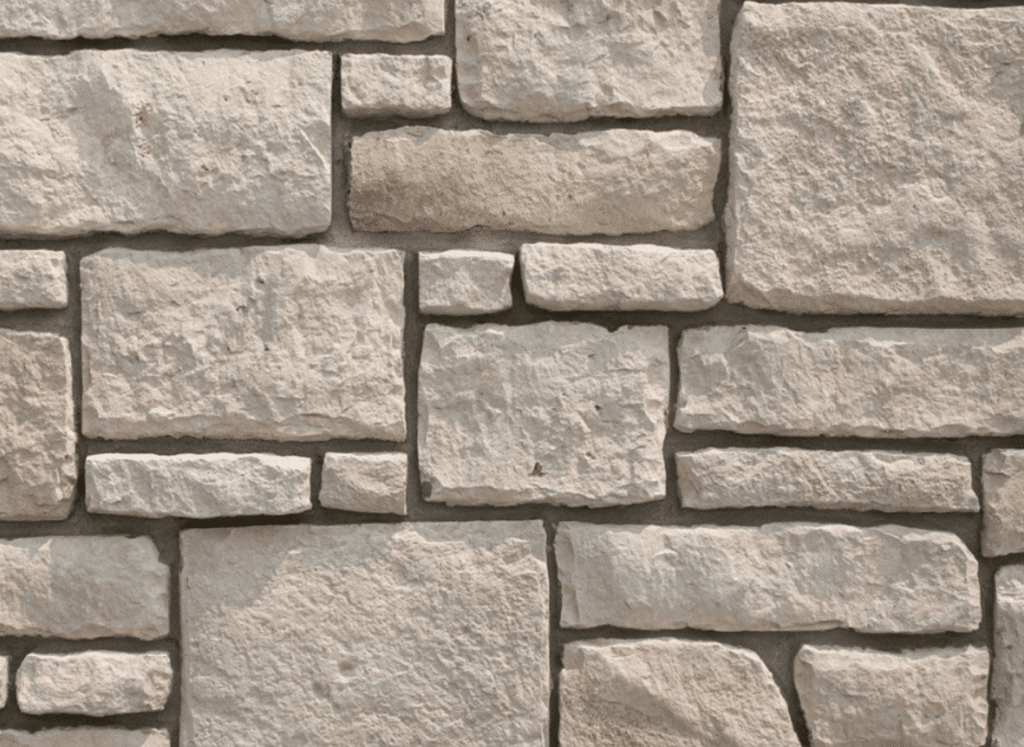 A close-up view of a sandstone stone siding wall featuring luxury stone veneer with rectangular and irregularly shaped stones in soft beige and light brown tones, arranged in a natural pattern.