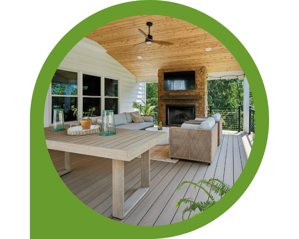 Covered outdoor composite deck with wood ceiling, fireplace, and lounge seating area.