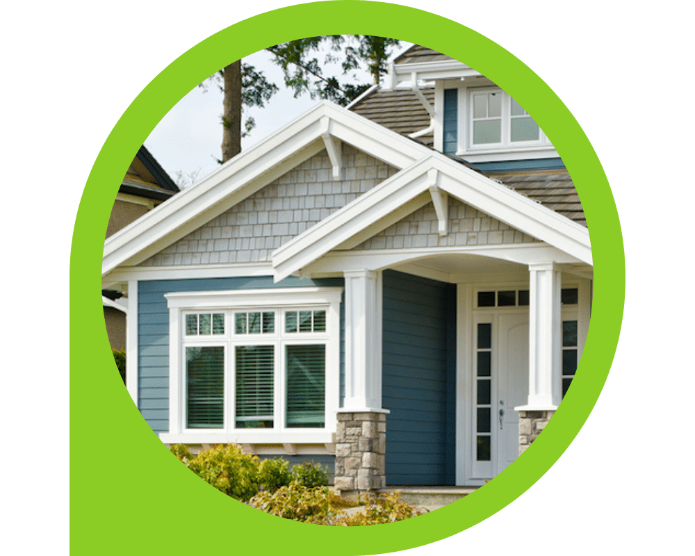 Blue house exterior with white trim, shake accents, and decorative siding details.